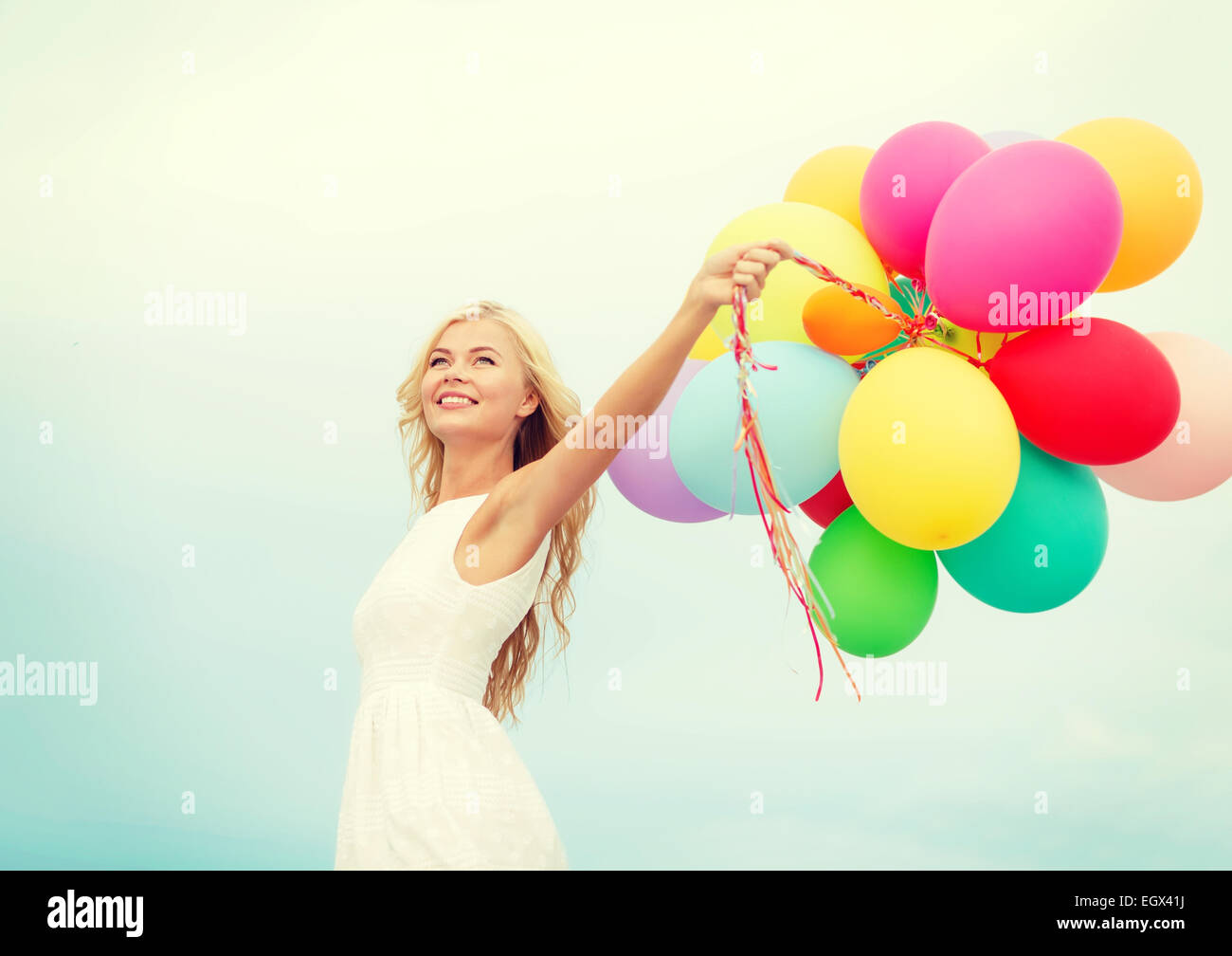 smiling woman with colorful balloons outside Stock Photo