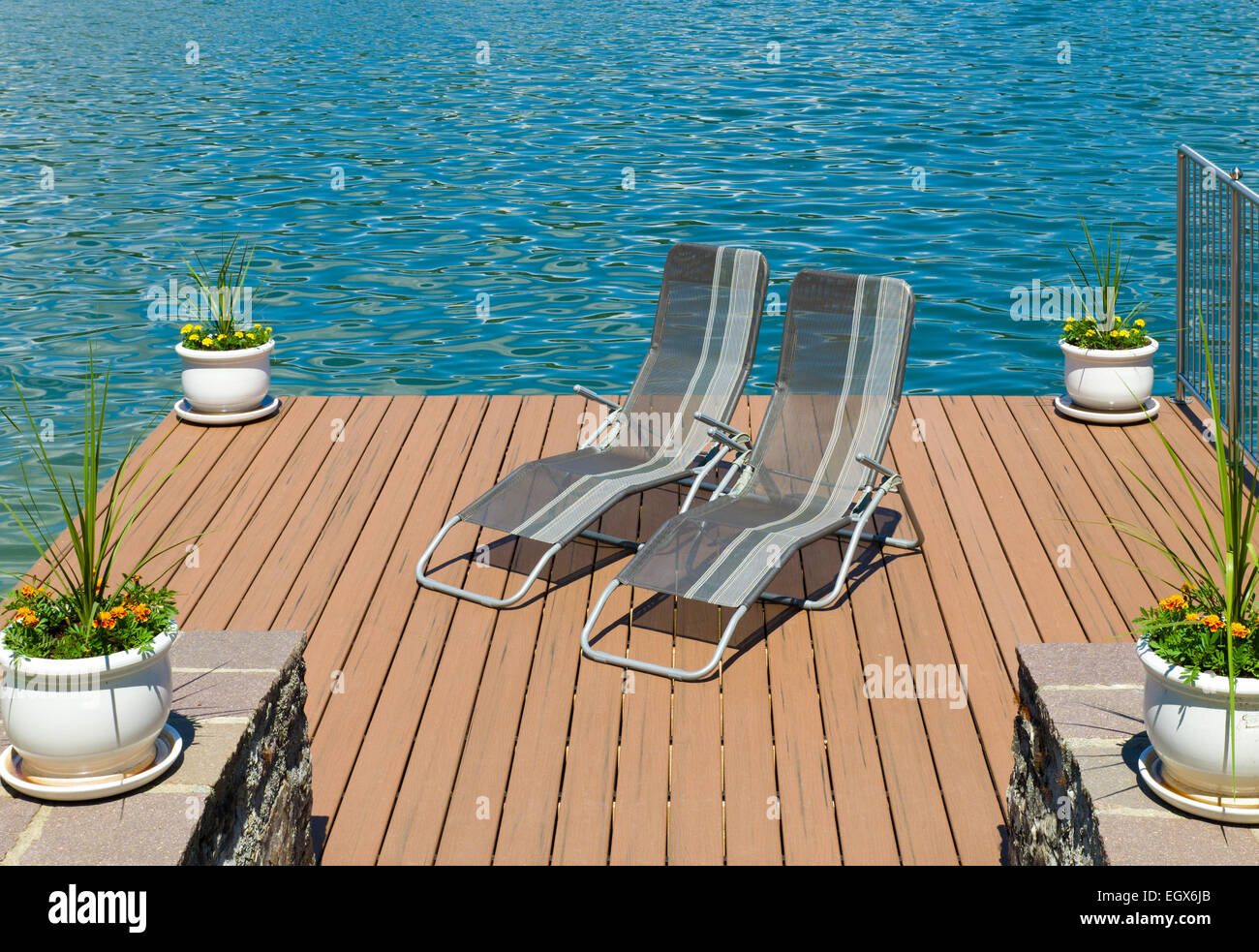 pair of lounge chairs on a wooden pier in Velden am worthersee in austria Stock Photo