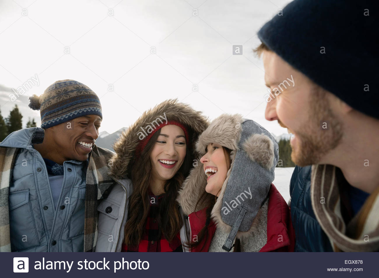 Couples in warm clothing laughing outdoors Stock Photo