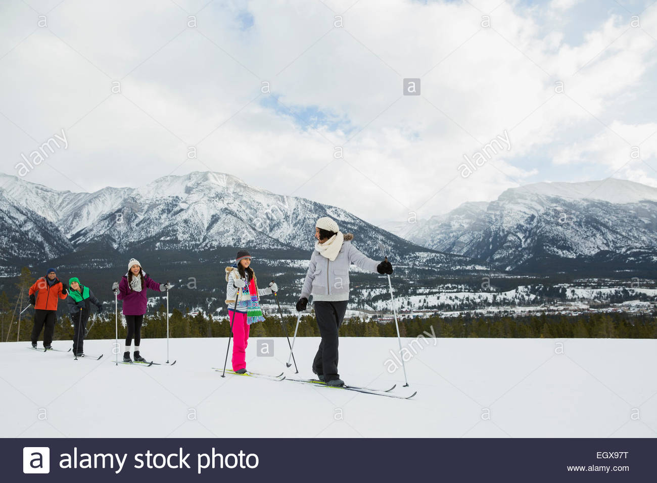 Family cross-country skiing in snowy field Stock Photo