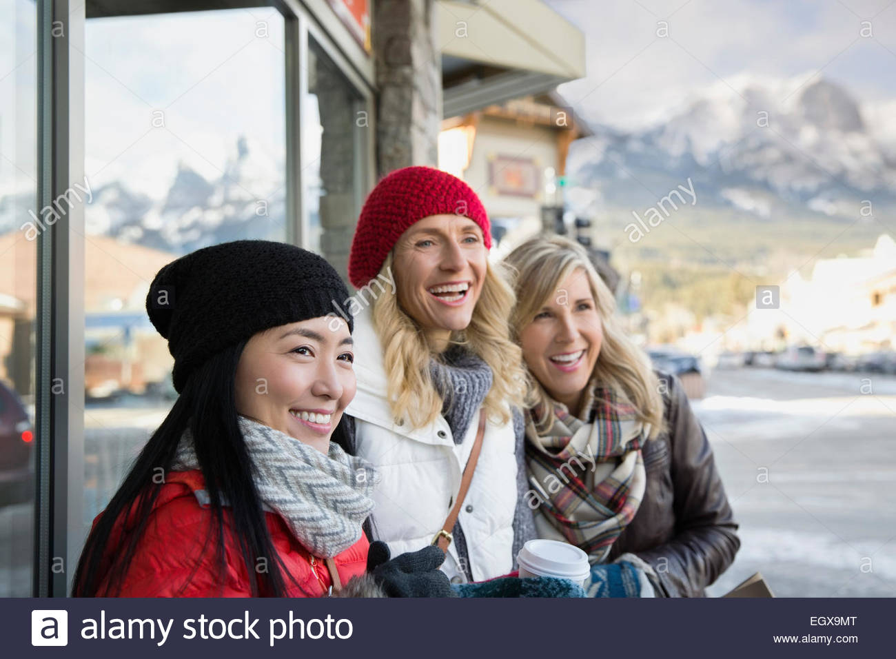 Smiling women in warm clothing at storefront Stock Photo Alamy