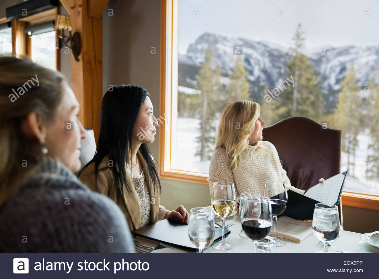 Women at restaurant table looking out window Stock Photo