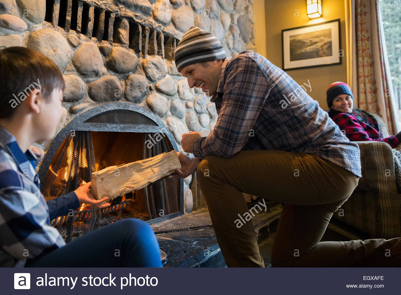 Father and son placing firewood on fire Stock Photo