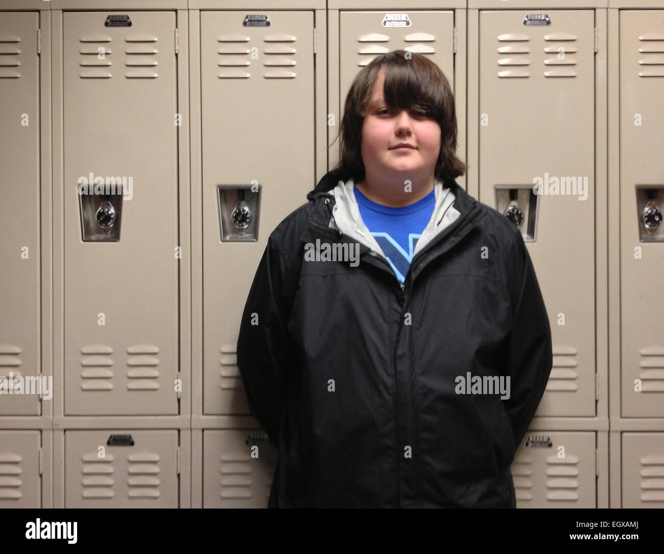 Caucasian student standing near school lockers Stock Photo