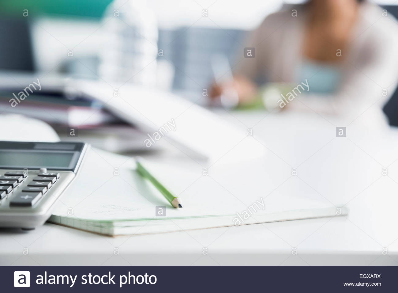 Pencil on notepad next to calculator Stock Photo