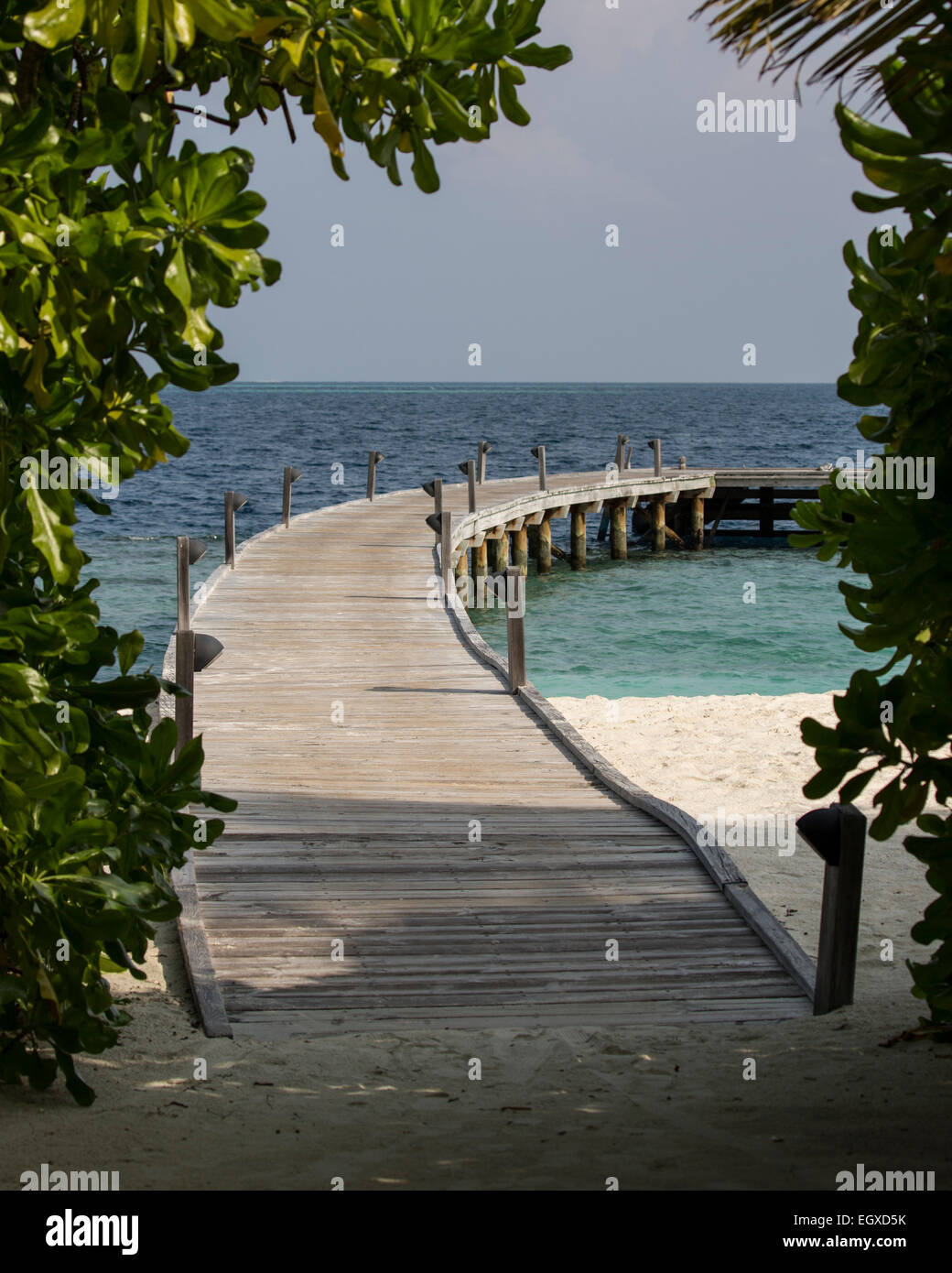 Wooden jetty leading to the ocean at a luxury resort in the Maldives ...