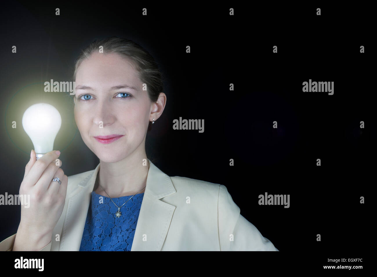 Pretty business woman wearing blue dress and yellow jacket holding a
