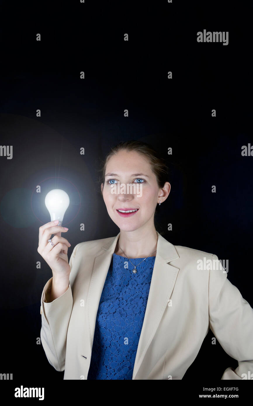 Pretty business woman wearing blue dress and yellow jacket holding a