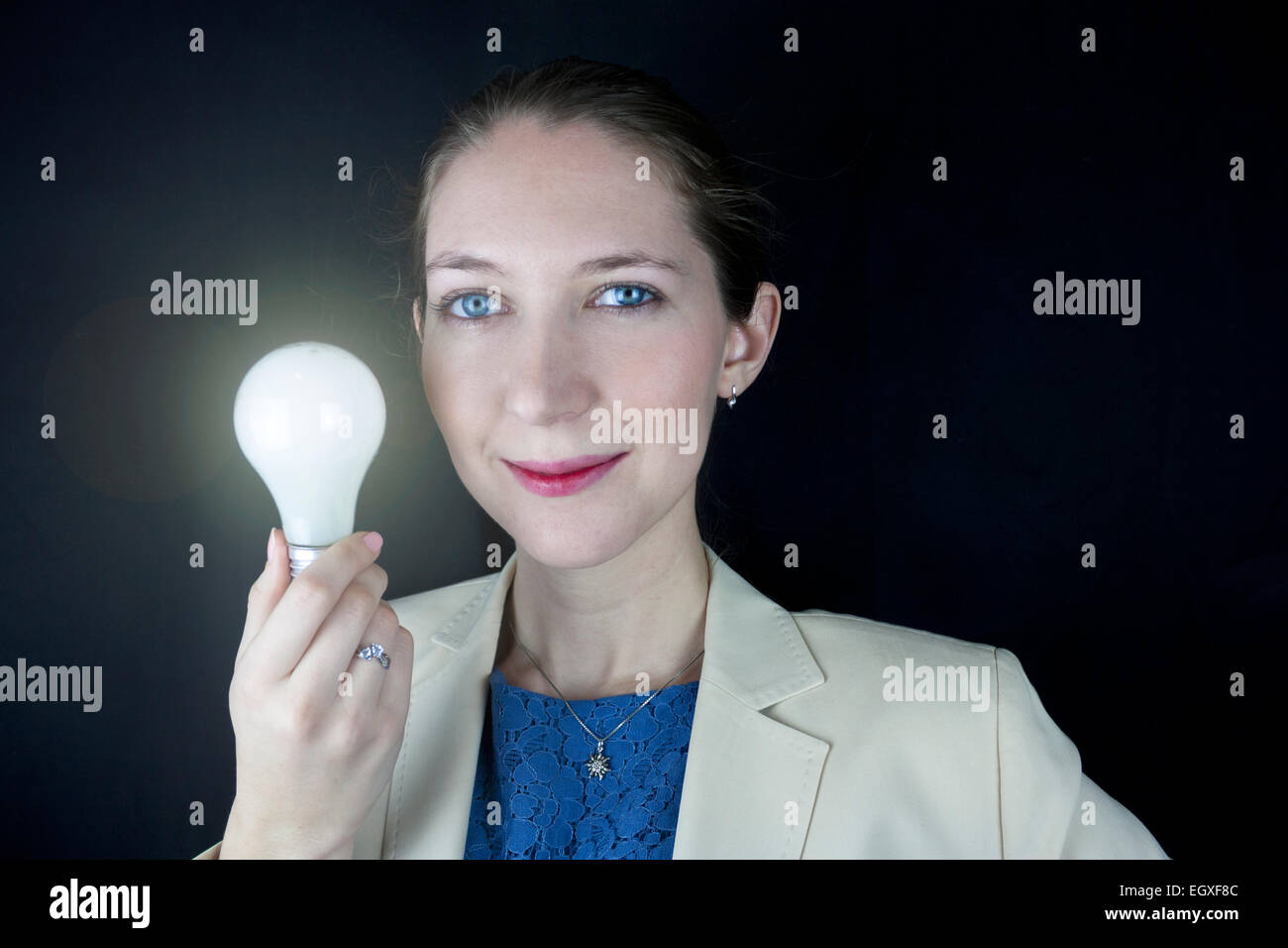 Pretty business woman wearing blue dress and yellow jacket holding a