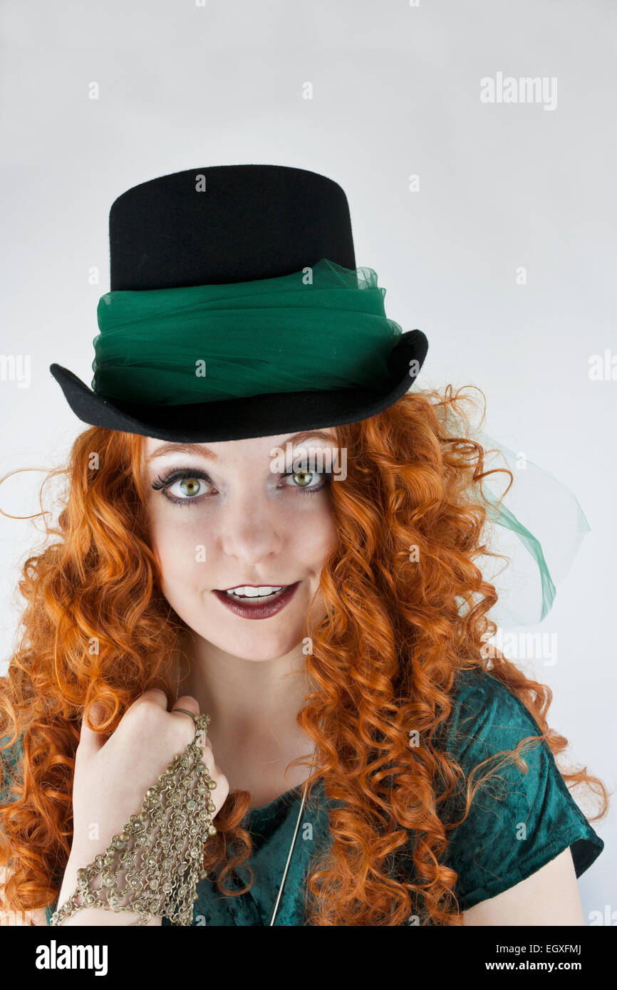 Close-up of pretty young woman with long, curly hair and tophat with green tulle Stock Photo