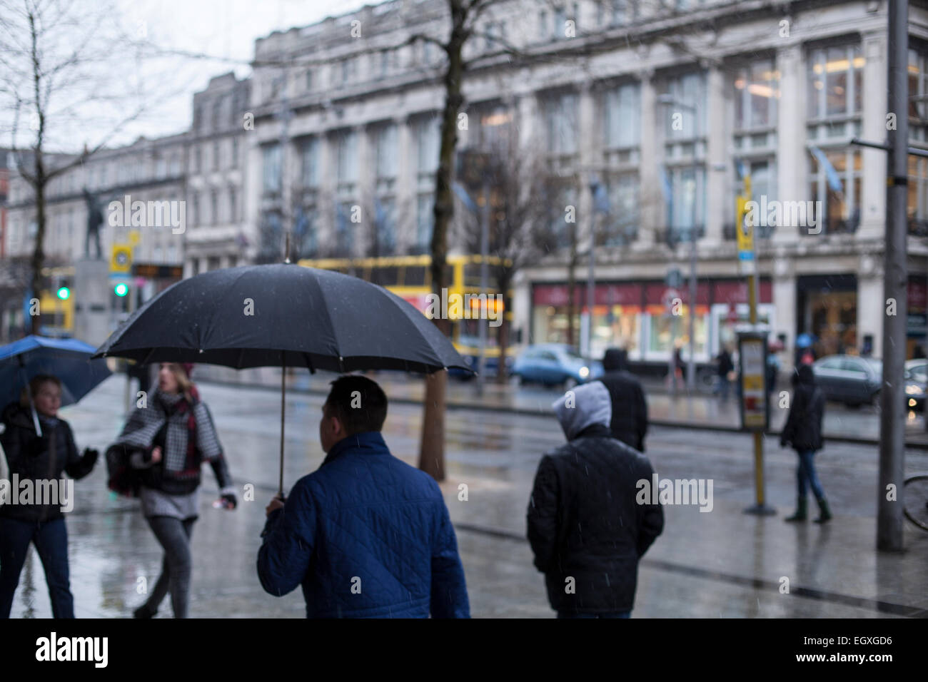 People with umbrellas on Dublin's O'Connell street in the rain on a Sunday Stock Photo Alamy