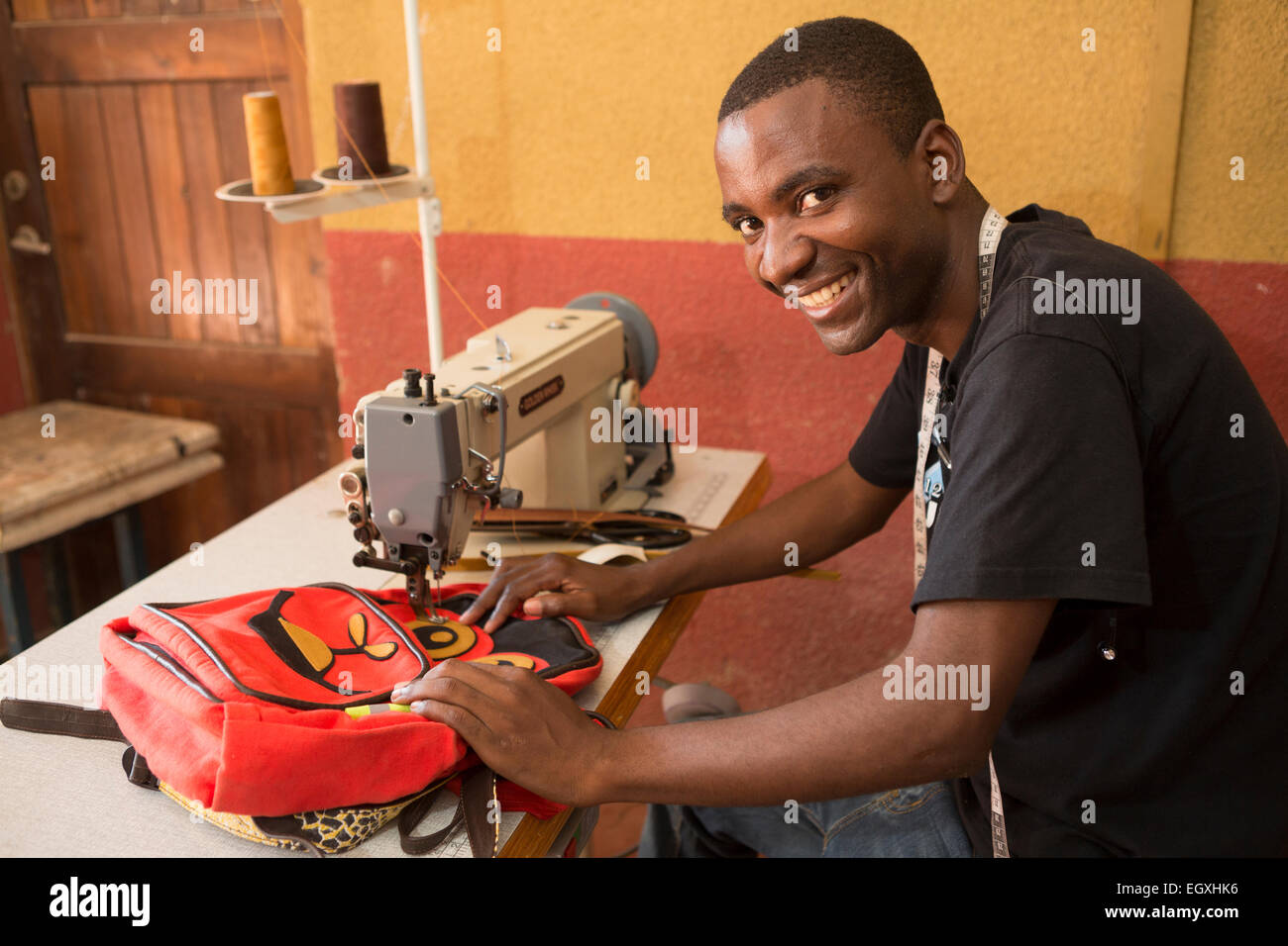 An artisan sews a school bag in a workshop in Dar es Salaam, Tanzania, East Africa. Stock Photo