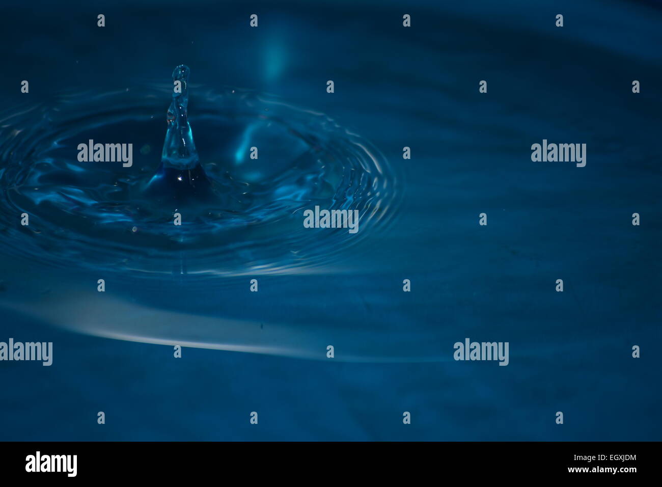 Water drop impact frozen mid splash with ripples and droplets Stock ...