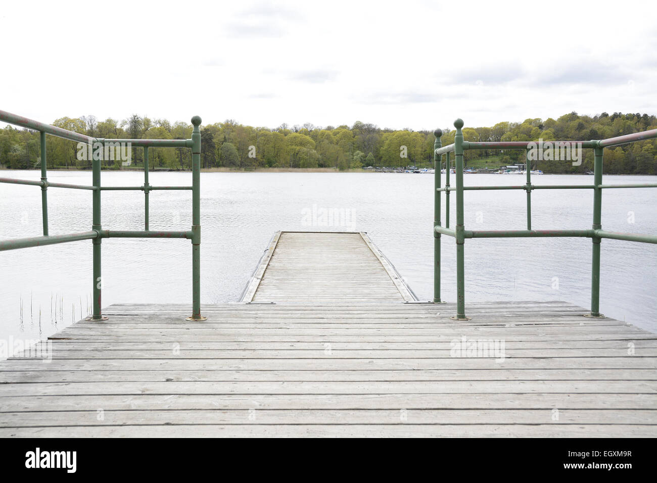 Wood pier with iron railing by lake, Stockholm, Sweden. Stock Photo
