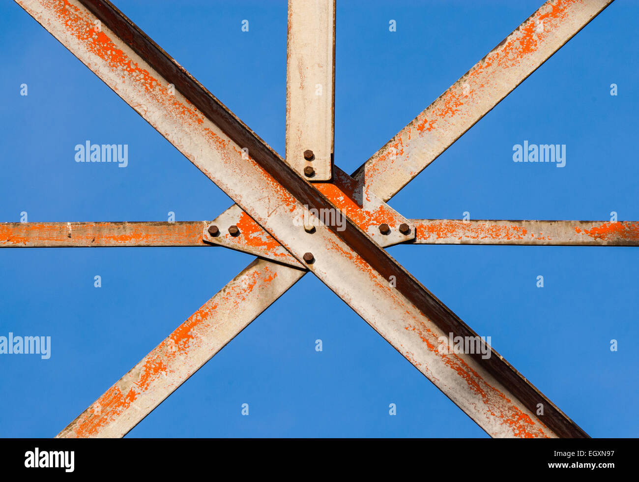 Worn metal girders crossing held together with plates and screws. Stock Photo