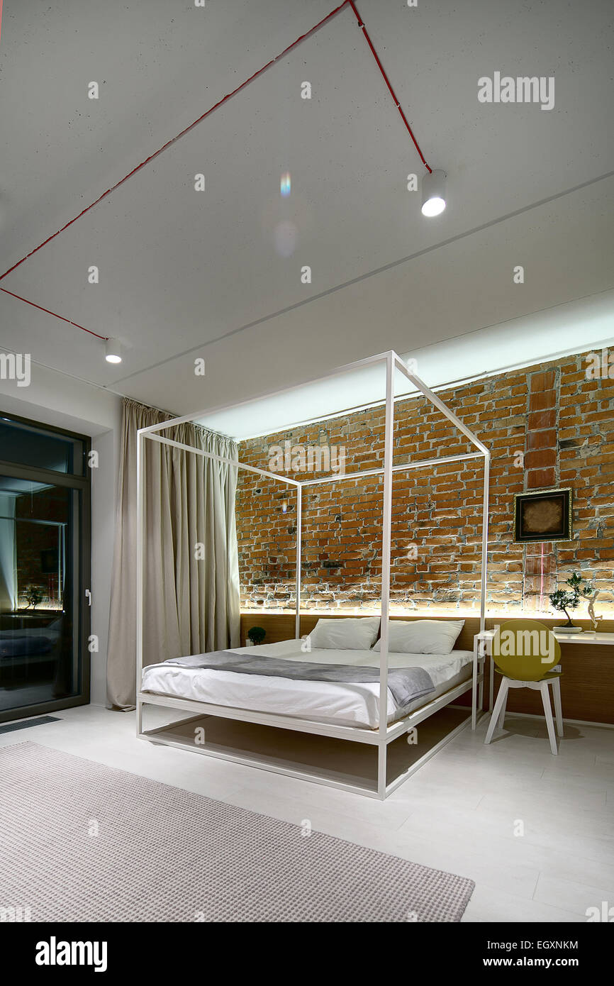 Bedroom in a modern loft style. Brick wall without plaster. Bed Stock Photo