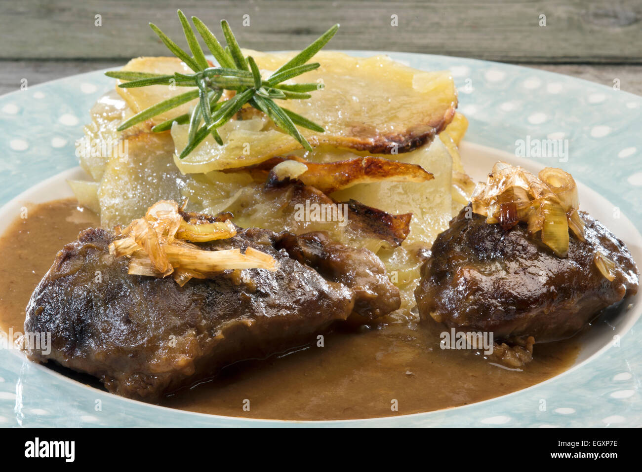 Welsh food braised pork cheeks in gravy with caramelized leek and