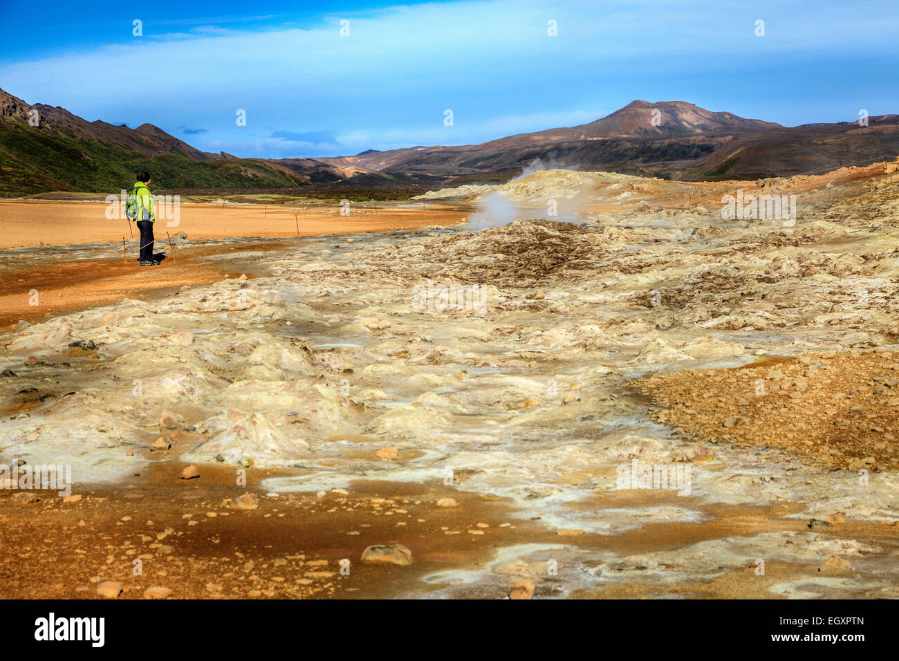 A tourist looking at steam vents at Hverir - geothermal field in Northern Iceland Stock Photo