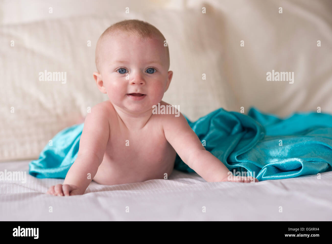 Sweet innocent young infant boy crawls around on the bed Stock Photo