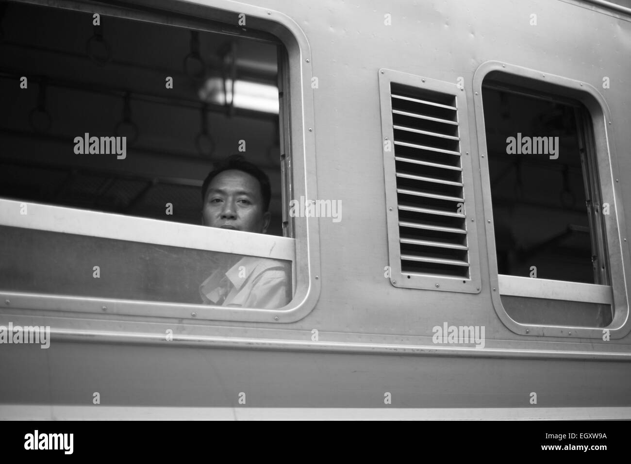 A passenger looks out of the open window of a train, Mahachai, Thailand. Stock Photo