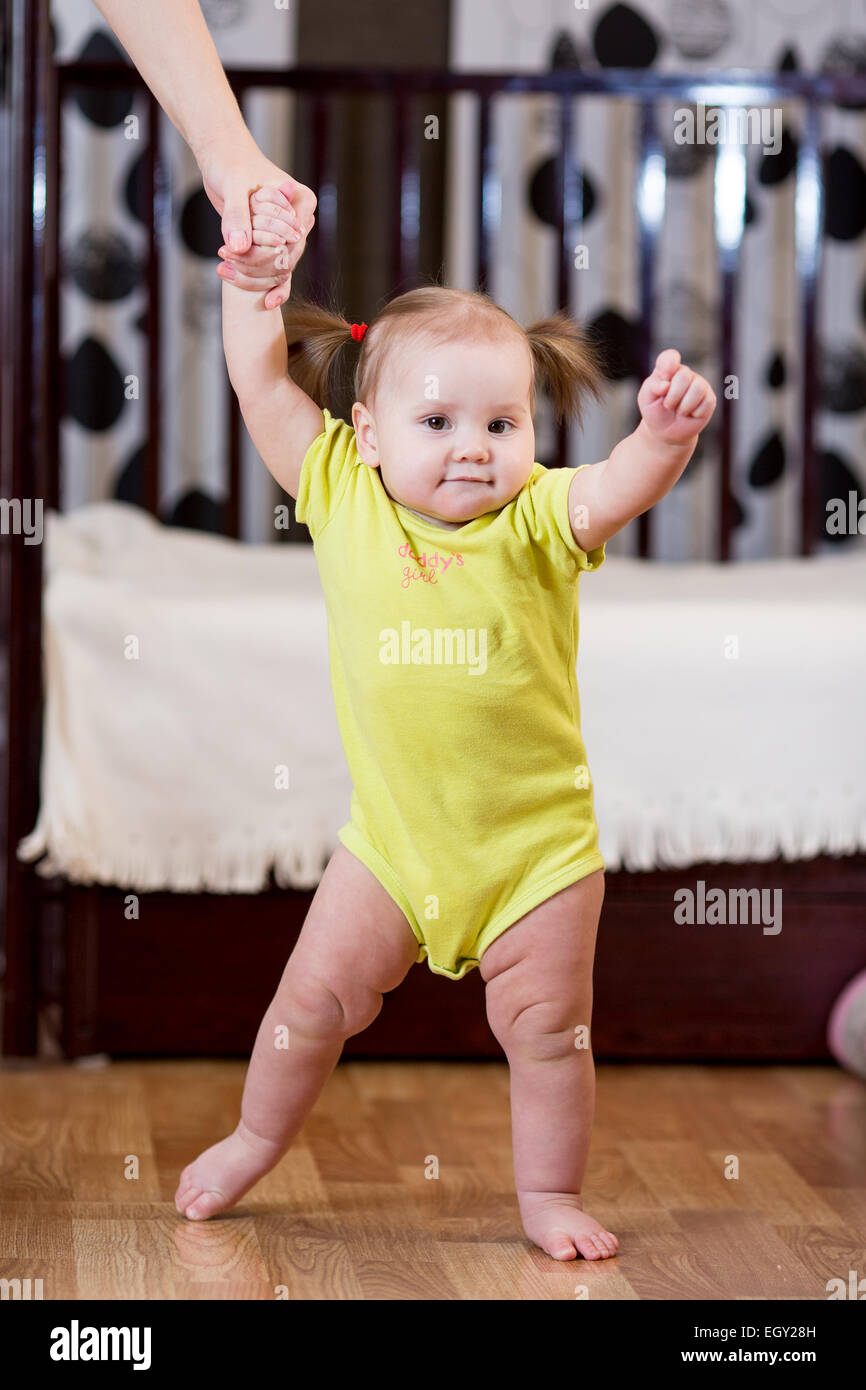 Cute toddler baby standing with support Stock Photo. toddler taking first s...