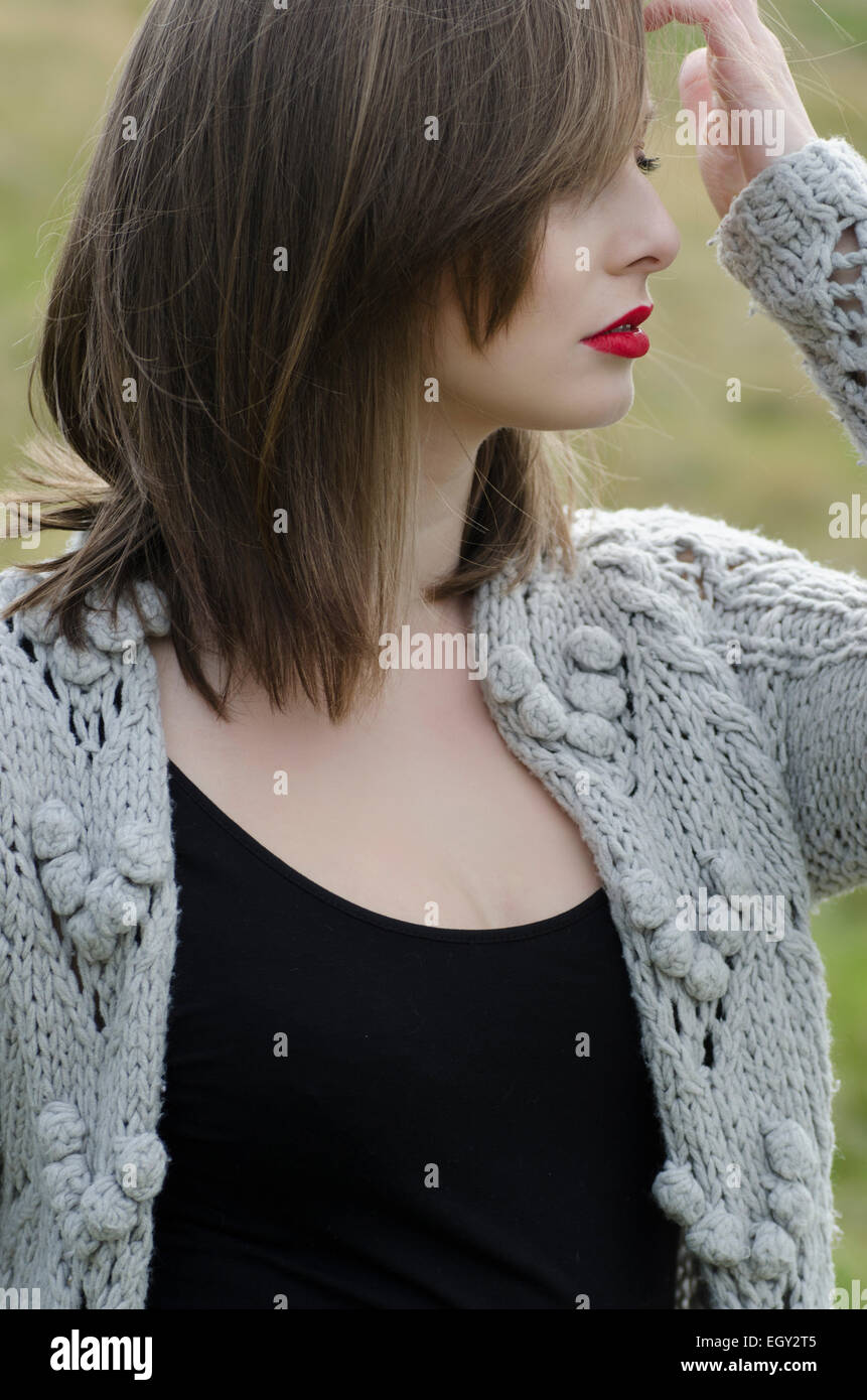 Portrait of a beautiful young woman in woolen cardigan outdoors Stock Photo