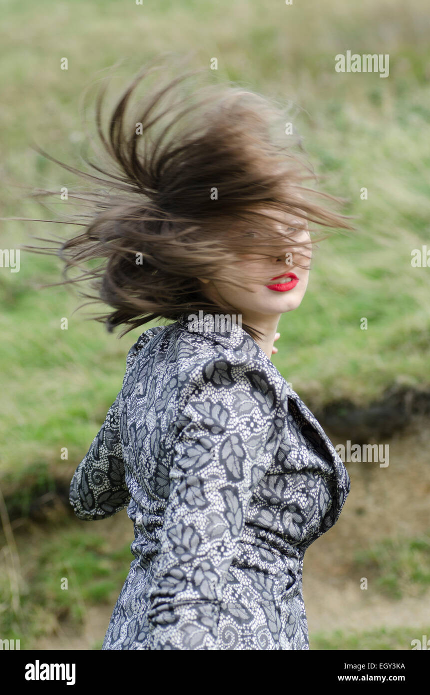 Scared young woman running away looking over shoulder Stock Photo