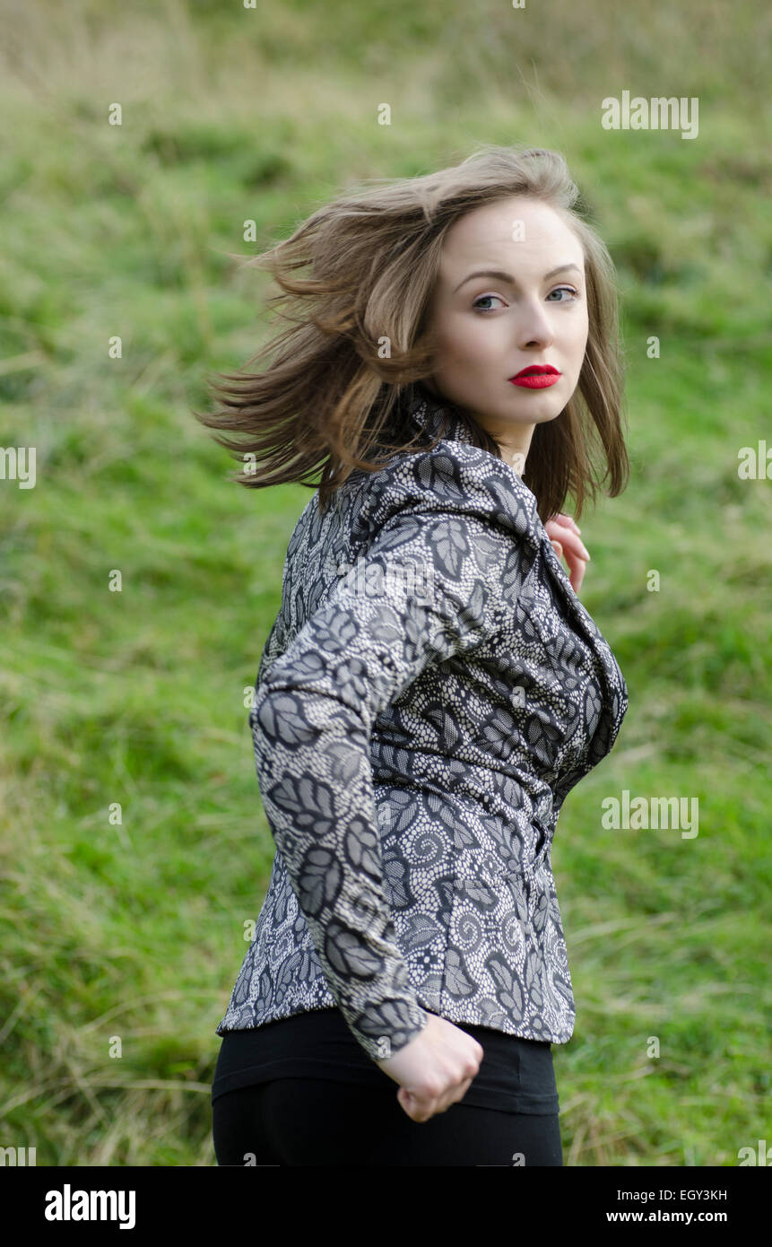 Scared young woman running away looking over shoulder Stock Photo