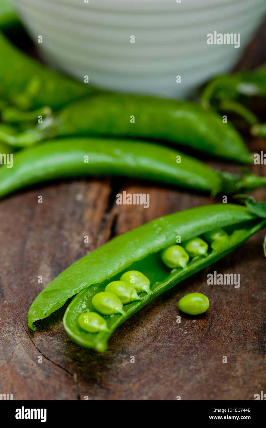 hearthy fresh green peas  over a rustic wood table Stock Photo