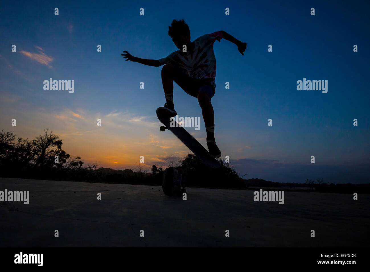 Man jumping on skateboard in sunset.Bali.Indonesia. Stock Photo