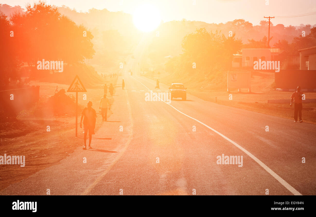 african road and people at sunset Stock Photo