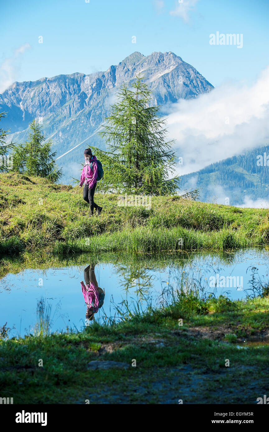 Austria, Altenmarkt-Zauchensee, young woman hiking in alpine landscape Stock Photo