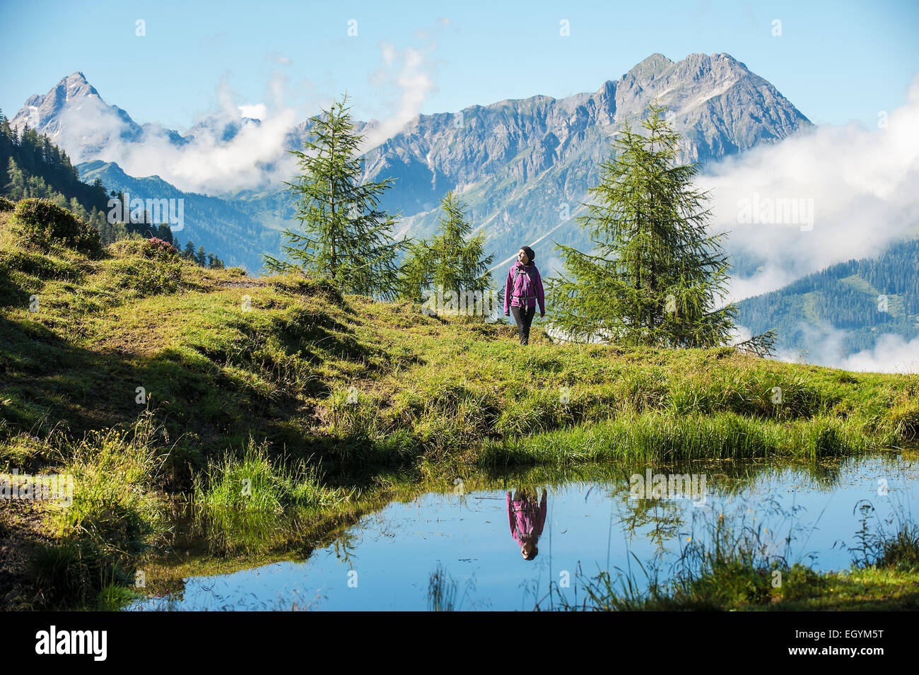 Austria, Altenmarkt-Zauchensee, young woman hiking in alpine landscape Stock Photo