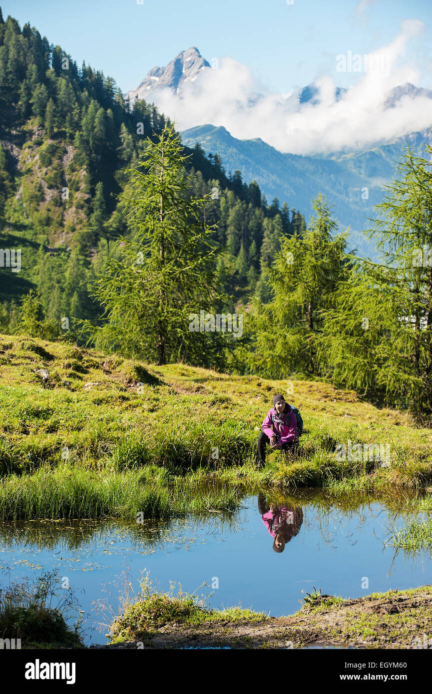 Austria, Altenmarkt-Zauchensee, young woman hiking in alpine landscape Stock Photo