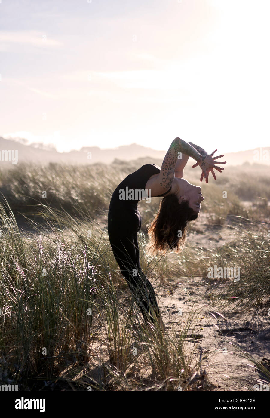 Spain, Asturias, Aviles, woman practicing yoga on the beach Stock Photo