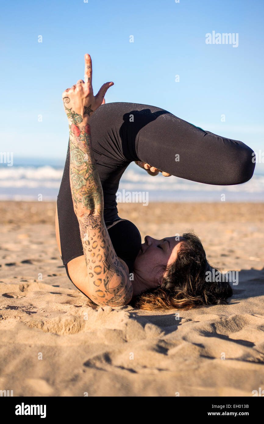Spain, Asturias, Aviles, woman practicing yoga on the beach Stock Photo