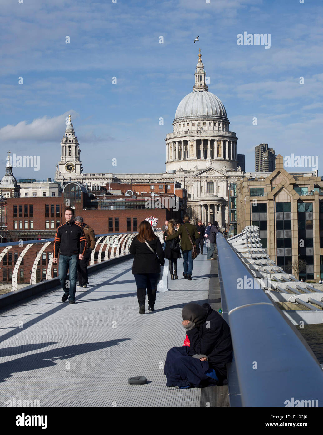 The Millennium bridge is a cold place for one of London's down-and-outs to go about his business Stock Photo