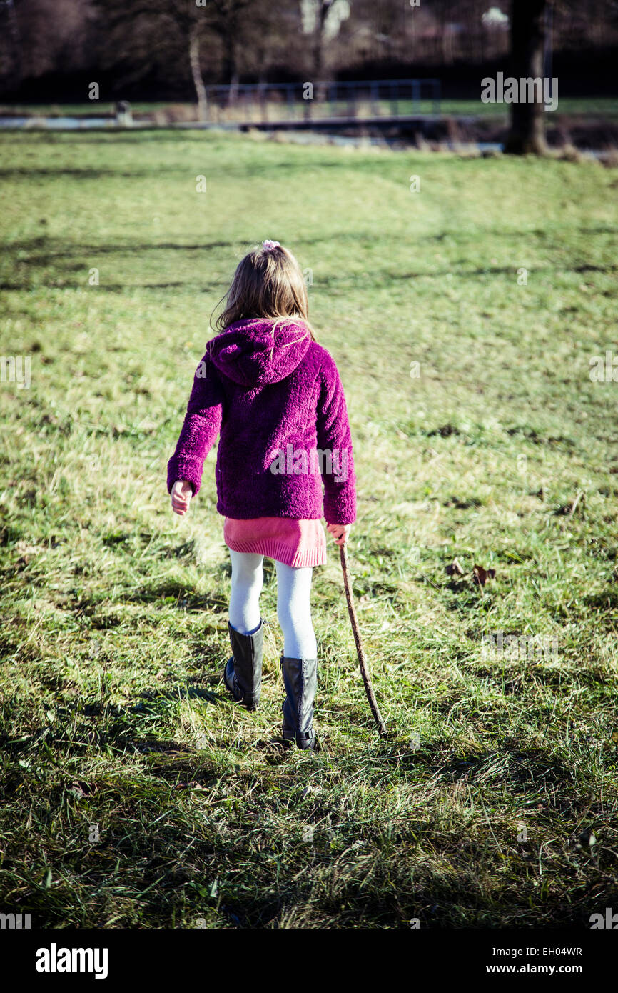 Little girl walking on a meadow Stock Photo - Alamy