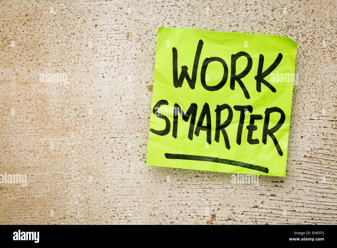 work smarter reminder on a green sticky note against rustic barn wood p productivity concept Stock Photo