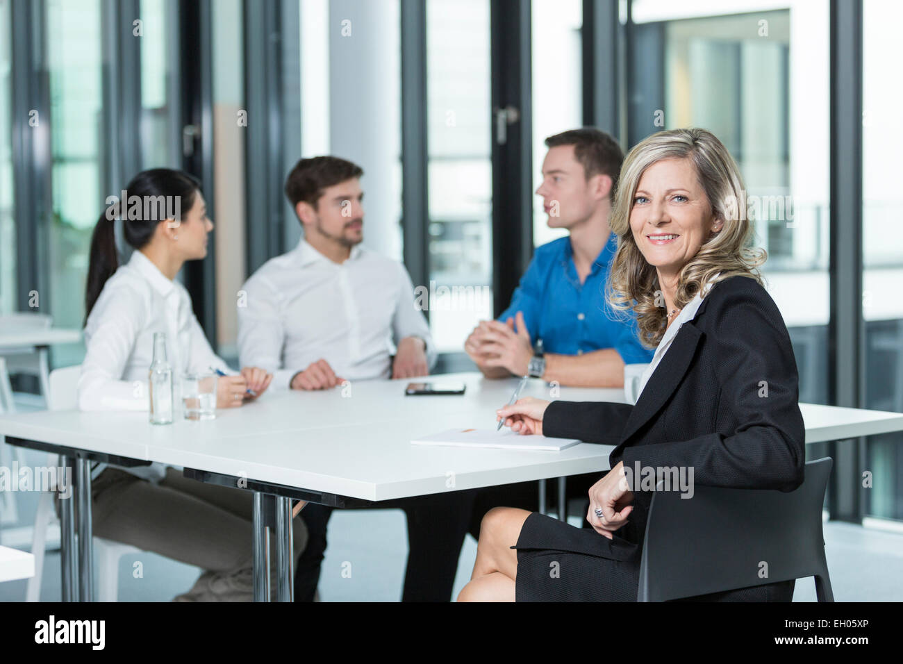 Meeting of four business people in a conference room Stock Photo - Alamy