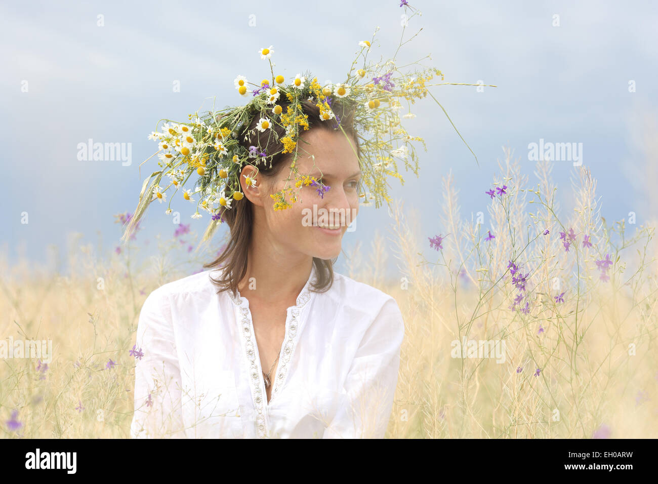 in a lush field girl with a wreath of flowers on her head Stock Photo ...