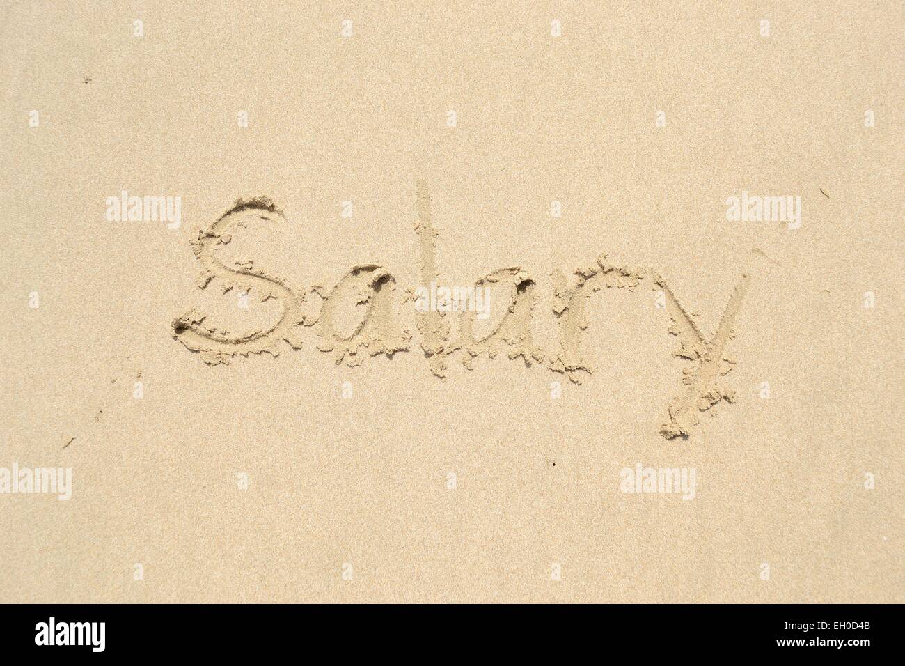 Hand drawn of a word salary on the beach Stock Photo