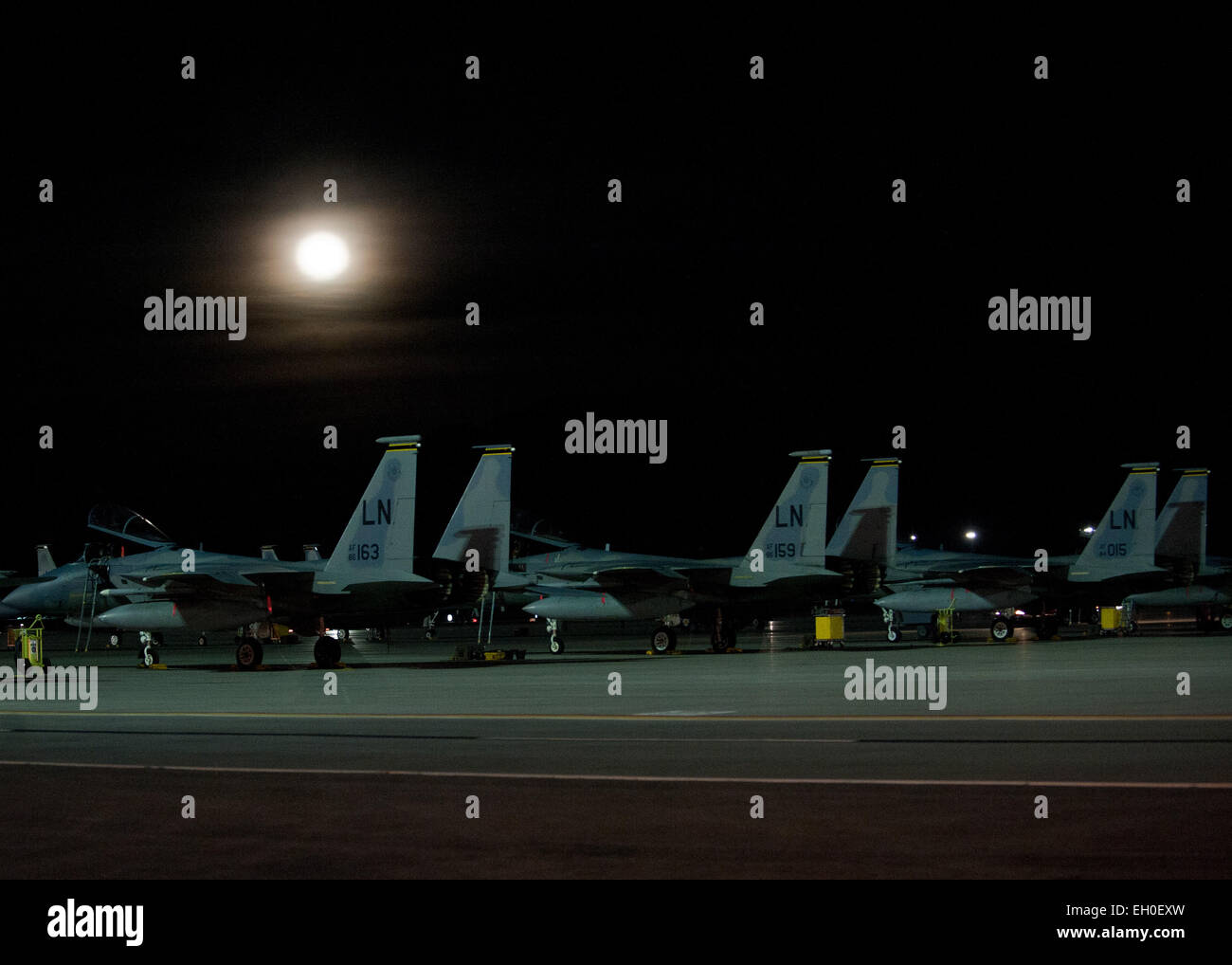 Three F-15 Eagles assigned to the 493rd Fighter Squadron at Royal Air Force Lakenheath, England, sit on the flightline under the moonlight during Red Flag 15-1 at Nellis Air Force Base, Nev., Feb. 4, 2015. Red Flag is a realistic combat training exercise involving the air, space and cyber forces of the U.S. and its allies, and is conducted on the vast bombing and gunnery ranges on the Nevada Test and Training Range during day and night operations. Stock Photo
