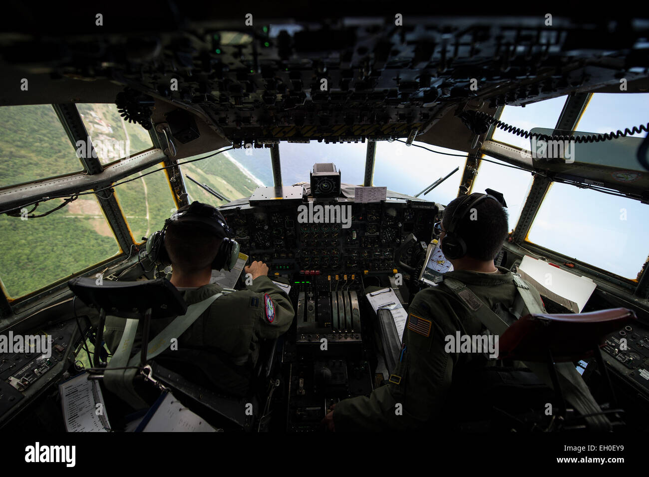 U.S. Air Force Capt. Ian Haig and 1st Lt. Eric Zane, 36th Airlift Squadron pilots, fly over Rota, Northern Mariana Islands, after delivering cargo used in a humanitarian assistance and disaster relief training event Feb. 15, 2015. Exercise Cope North 15 enhances humanitarian assistance and disaster relief crisis response capabilities between six nations, and lays the foundation for regional cooperation expansion during real-world contingencies in the Asia-Pacific region. Stock Photo