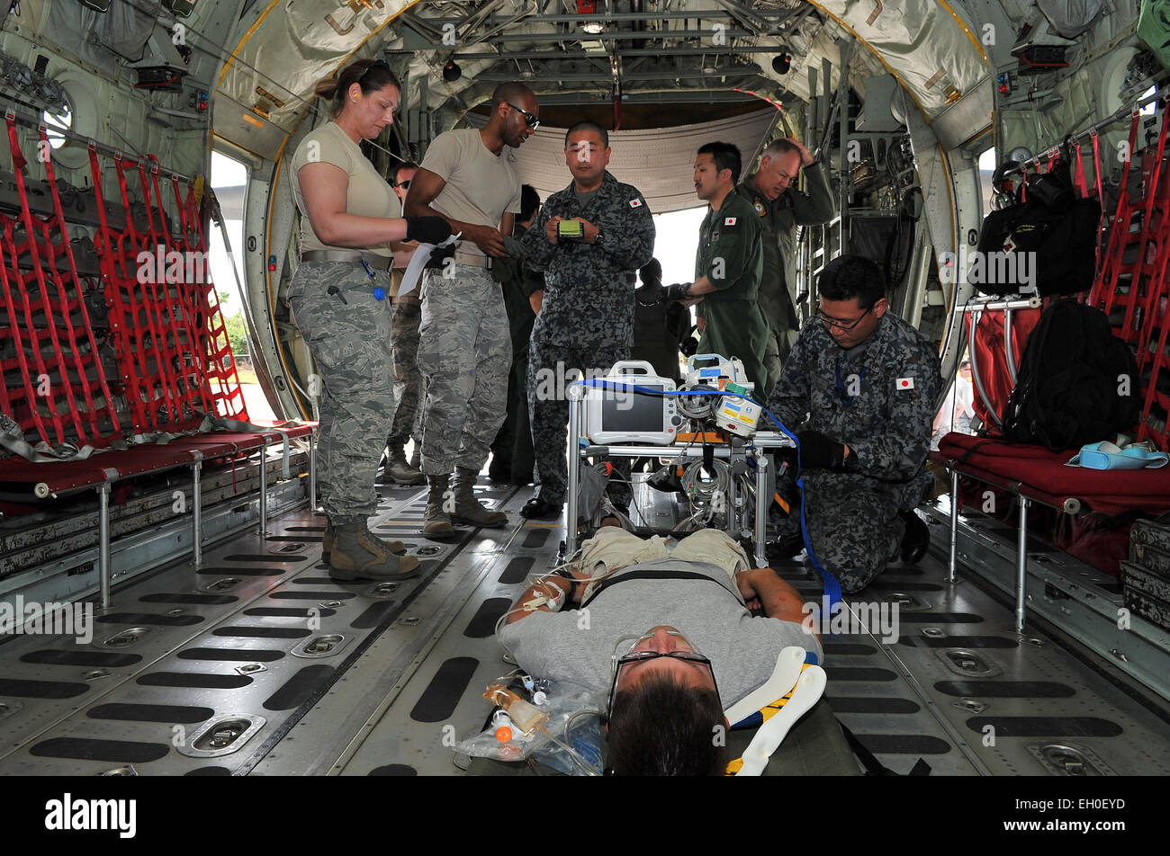 U.S. Air Force Airmen transfer a simulated critical care patient to a Japan Air Self-Defense Force aeromedical evacuation team at Sinapalo, Rota, Feb. 16, 2015. Exercise Cope North 15 enhances humanitarian assistance and disaster relief crisis response capabilities between six nations, and lays the foundation for regional cooperation expansion during real-world contingencies in the Asia-Pacific region. Stock Photo