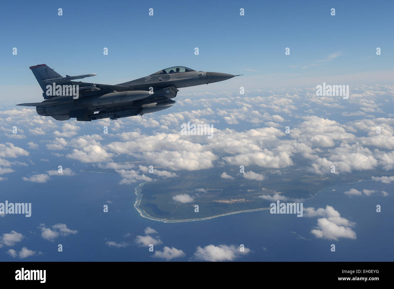 A U.S. Air Force F-16 Fighting Falcon from the 14th Fighter Squadron flies along the coastline of Guam before joining on an aircraft formation at Cope North 15, Feb. 17, 2015. Through training exercises like Exercise Cope North 15, the U.S., Japan and Australia air forces develop combat capabilities, enhancing air superiority, electronic warfare, air interdiction, tactical airlift and aerial refueling. Stock Photo