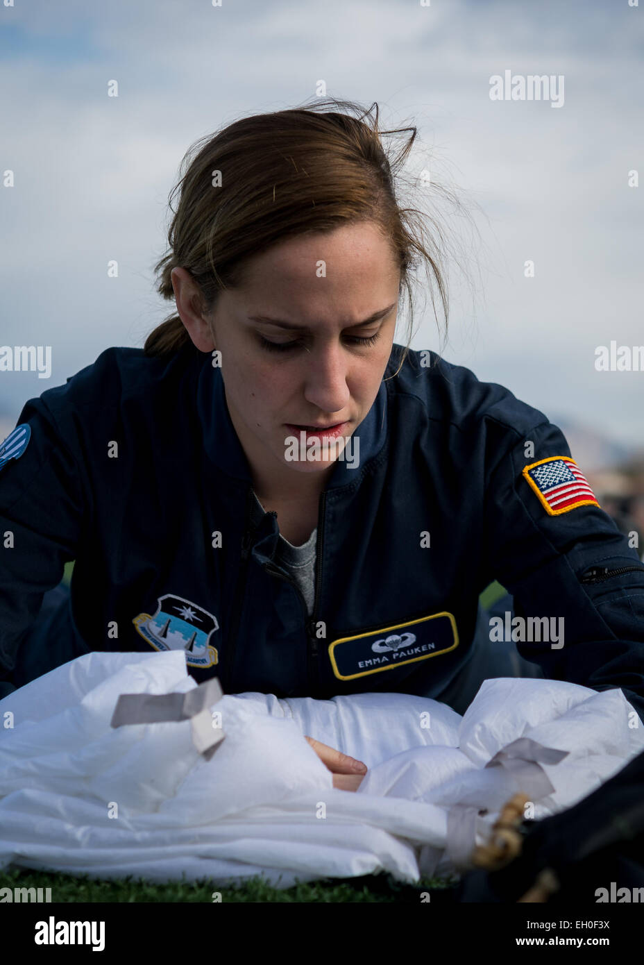 Cadet 2nd Class Emma Pauken, 98th Flying Training Squadron Wings of Blue parachutist, a Keene, NH native, packs her equipment after preforming in an aerial demonstration for the opening ceremonies of the Air Force Wounded Warrior (AFW2) 2015 Trials  on Nellis Air Force Base, NV, February 27. The AFW2 Trials are an adaptive sports event designed to promote the mental and physical well-being of seriously ill and injured military members and veterans. More than 105 wounded, ill or injured service men and women from around the country will compete for a spot on the 2015 U.S. Air Force Wounded Warr Stock Photo