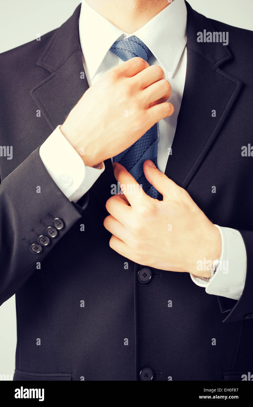man adjusting his tie Stock Photo - Alamy
