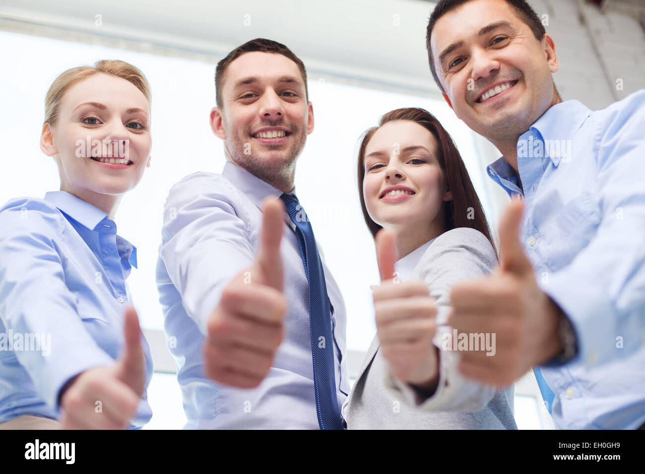 smiling business people showing thumbs up Stock Photo - Alamy