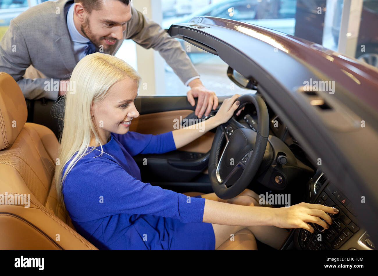 happy couple buying car in auto show or salon Stock Photo